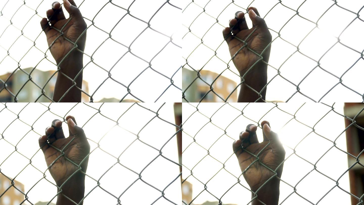 手握链环围栏国外监狱外国犯人关押罪犯
