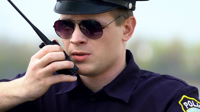 坚定的警官用对讲机交流信息