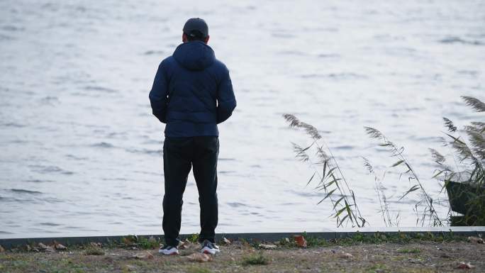 男人一个人站在河边迷茫思考