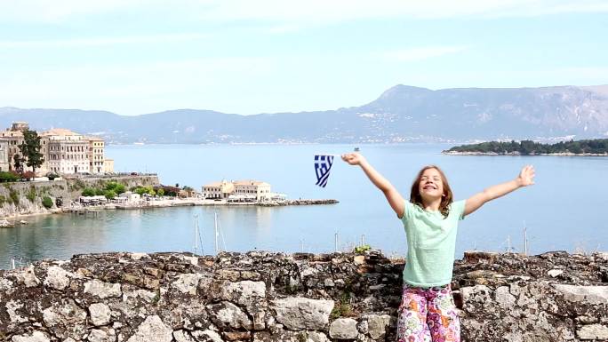 快乐的小女孩挥舞着希腊国旗
