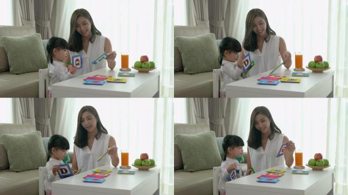 母亲和女儿玩字母卡