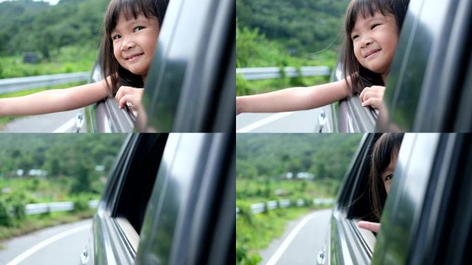 小孩坐在汽车旁感受旅游的气氛