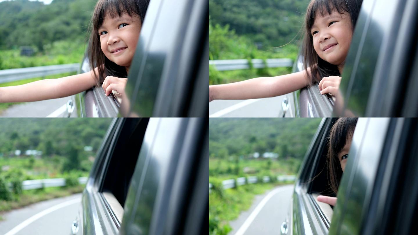 小孩坐在汽车旁感受旅游的气氛