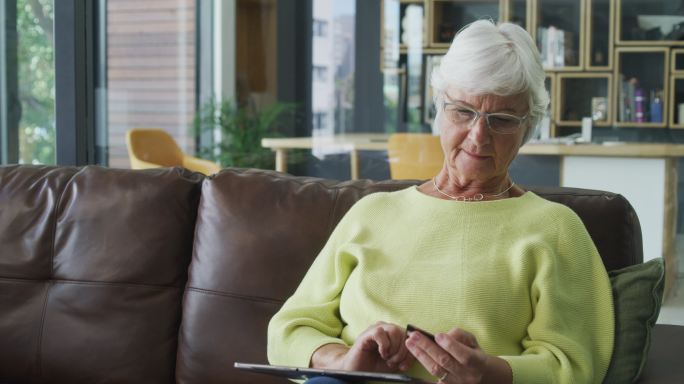 一位年长女性在家使用数字平板电脑