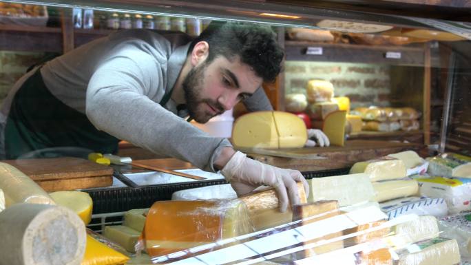 男子在整理橱窗的奶酪
