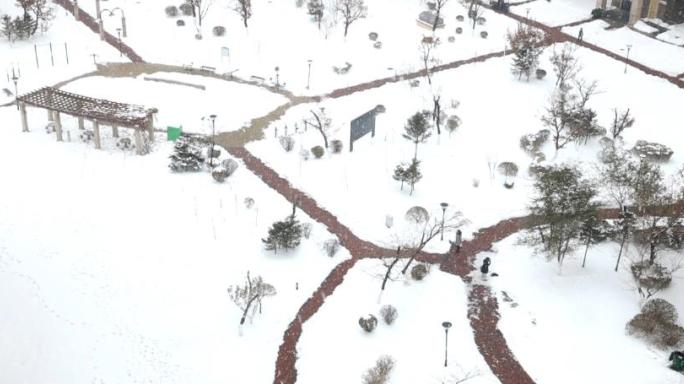 雪中的行人下雪天公园雪花园区下雪小区雪景