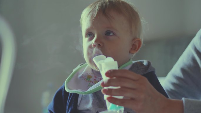 男婴使用气雾剂进行吸入器治疗