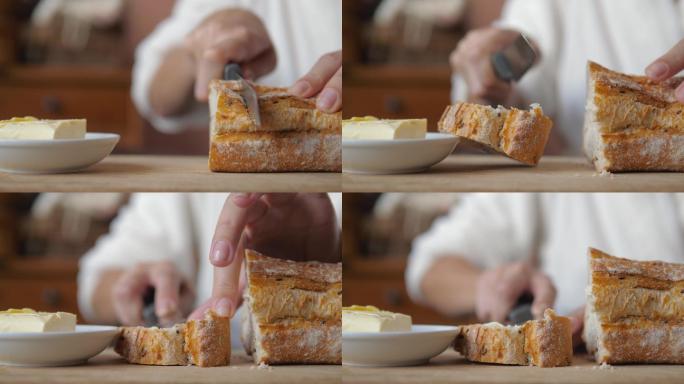 女性用小刀切面包并涂上黄油