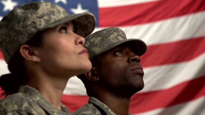 两名美国士兵抬头看着国旗