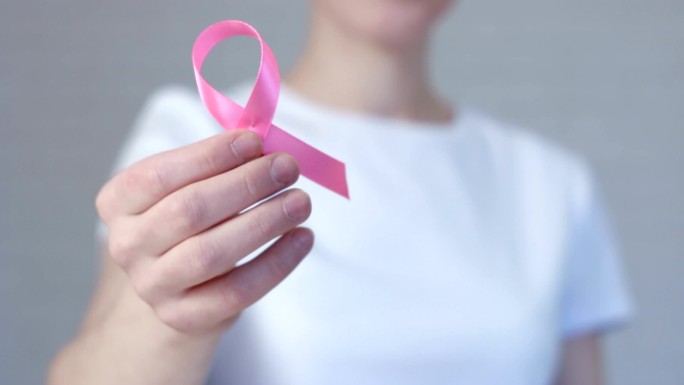 手持粉色乳腺癌意识丝带的女性-乳腺癌意识