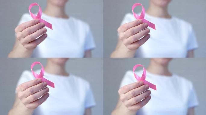 手持粉色乳腺癌意识丝带的女性-乳腺癌意识