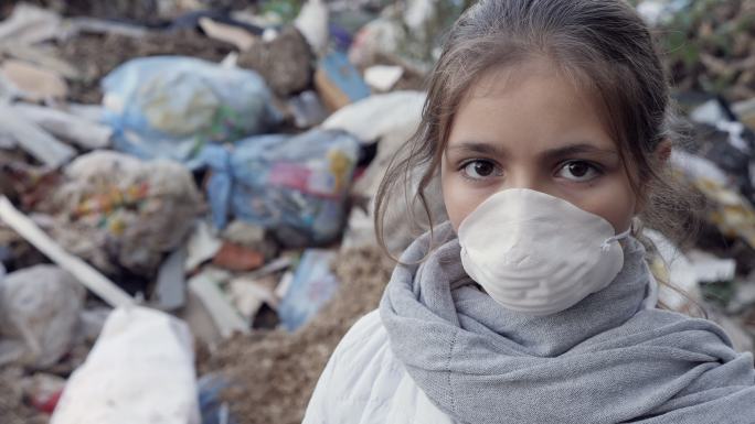 垃圾场一个戴着口罩的小女孩