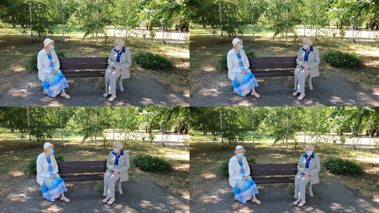 坐在公园里进行社交疏远的老年妇女。