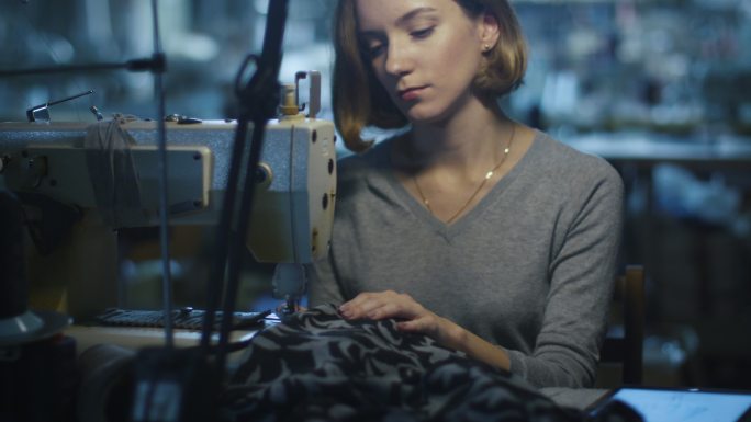 女制衣工人正在一家服装厂上夜班