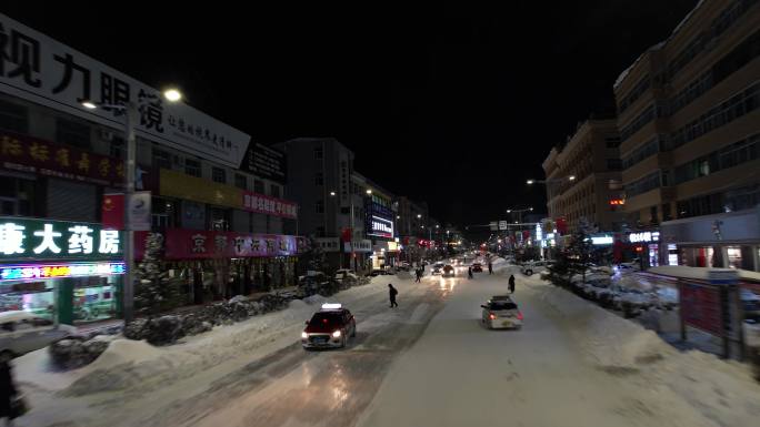 低角度航拍夜晚城市积雪的街道