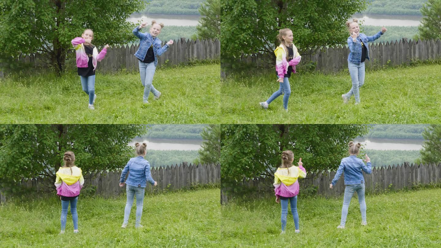 两个快乐的女孩在后院的草坪上跳舞