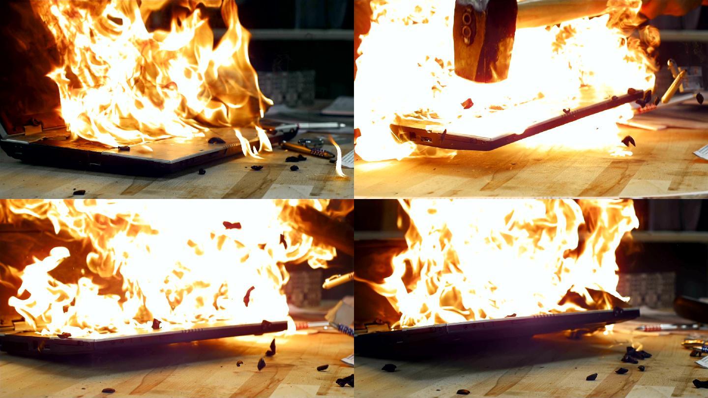 锤子击中燃烧的笔记本电脑