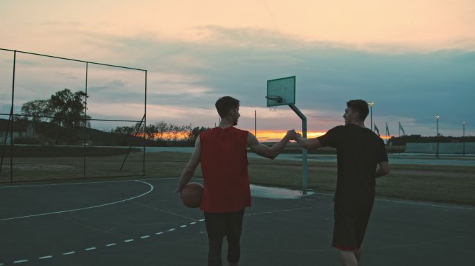黄昏时分年轻人在室外篮球场上打篮球
