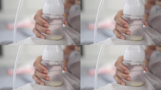 年轻的母亲用电动吸奶器为她的婴儿吸奶。