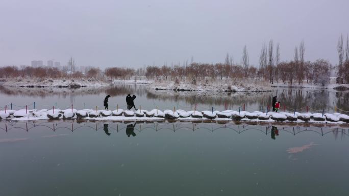 下雪天湖中石头路游客