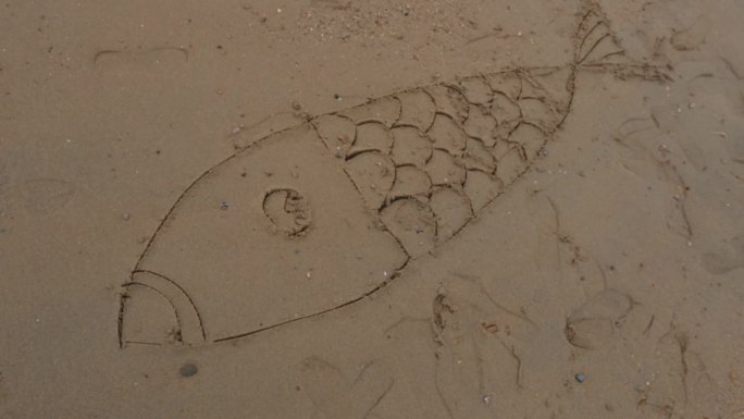 妈妈带孩子在海边玩沙子画画
