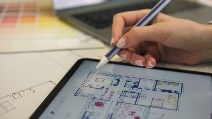 建筑师使用平板电脑绘制房屋蓝图