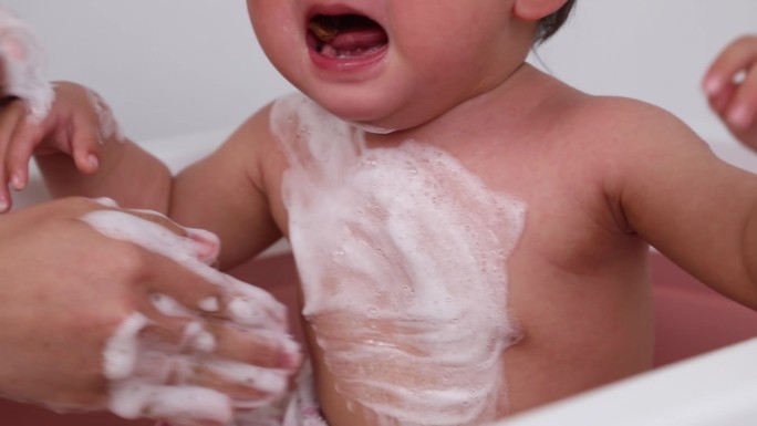 妈妈给宝宝婴儿新生儿哭闹洗澡玩水视频素材