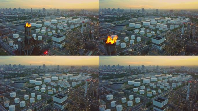 日出时城市中带燃烧火炬、储罐的化工厂或炼油厂鸟瞰图