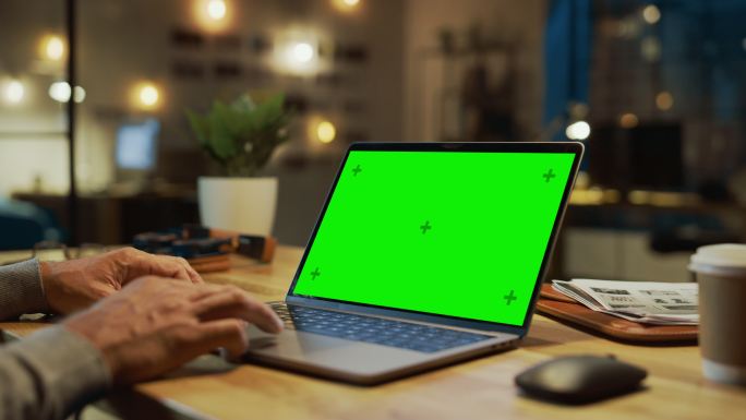 手上的特写镜头在一台模拟绿色屏幕的笔记本