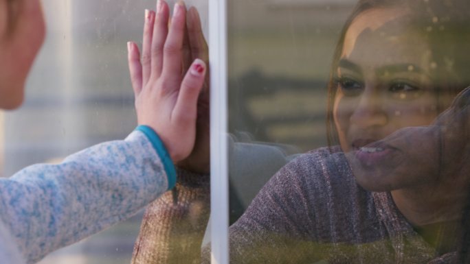 两位年轻的女性朋友通过一扇窗户联系在一起