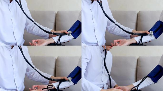 医生坐在沙发上测量女患者的血压
