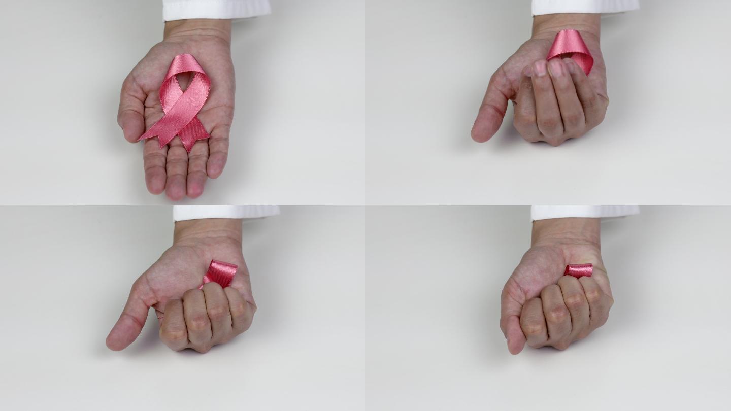 手拿粉红色乳腺癌意识丝带的医生