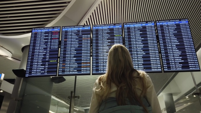 在国际机场看航班信息的女人