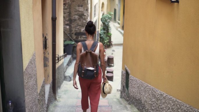一个拿着包的女人走在意大利的小街上