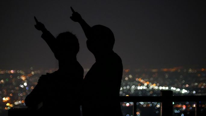 年轻夫妇在夜间观看星星