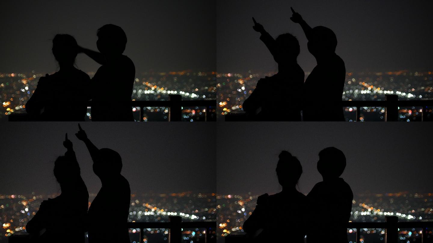 年轻夫妇在夜间观看星星