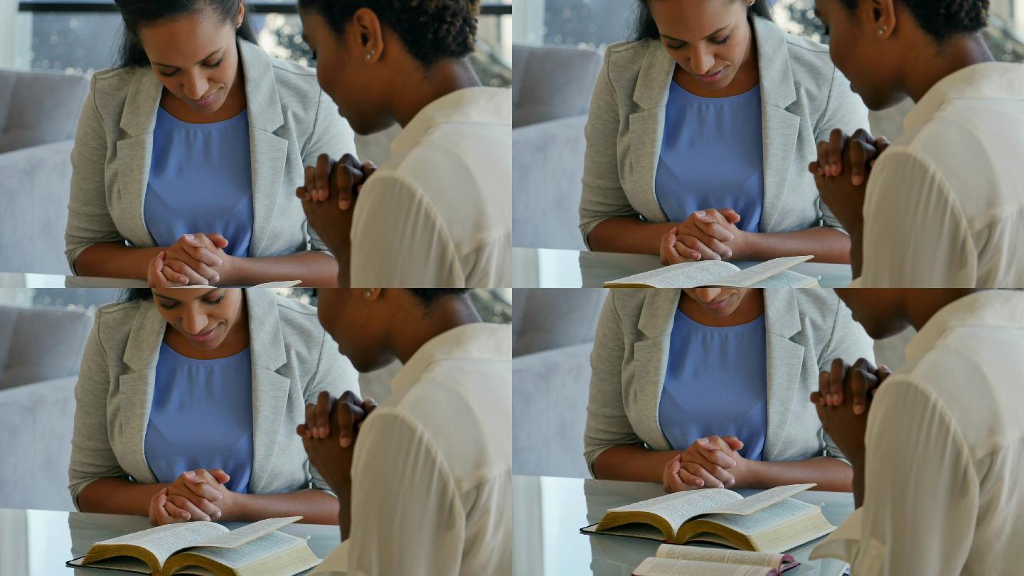 两位女性朋友在圣经学习期间一起祈祷