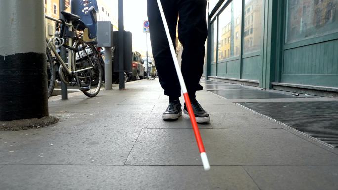 盲人拿着手杖在街上行走