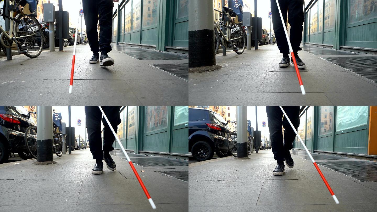 盲人拿着手杖在街上行走
