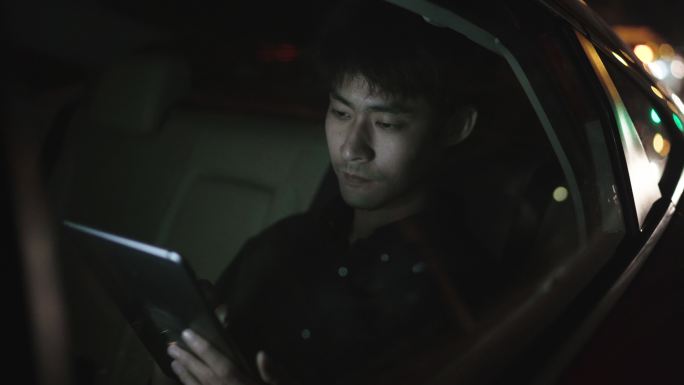 一个自由职业者晚上在车里操作平板电脑