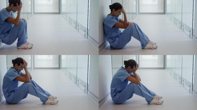 悲伤的女外科医生坐在走廊里