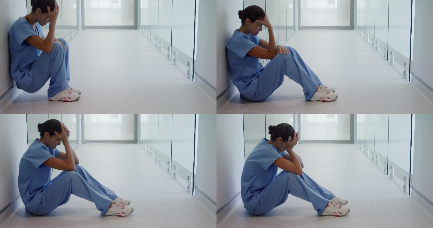 悲伤的女外科医生坐在走廊里