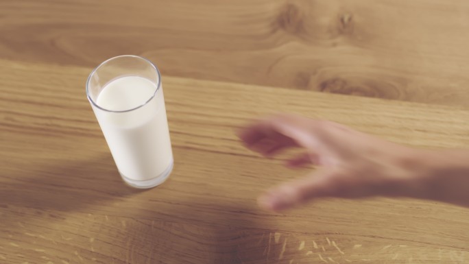 一只手拿起一杯牛奶