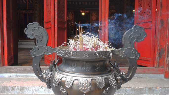 在越南河内玉山寺的火盆里烧香。