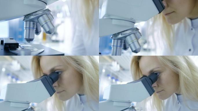 一个医学研究科学家观察显微镜的特写镜头。