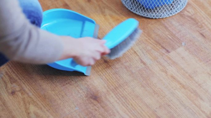 人，家务和家政概念-妇女用簸箕和刷子在家里扫地