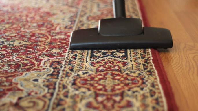 一位家庭主妇用吸尘器清扫家里的地毯