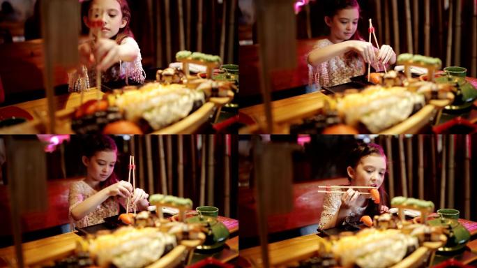 小女孩在一家日本餐馆尝试寿司卷