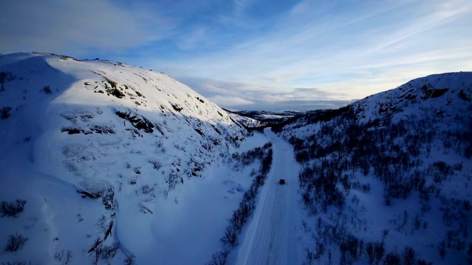 通过冬季山区景观的乡村道路的航拍。