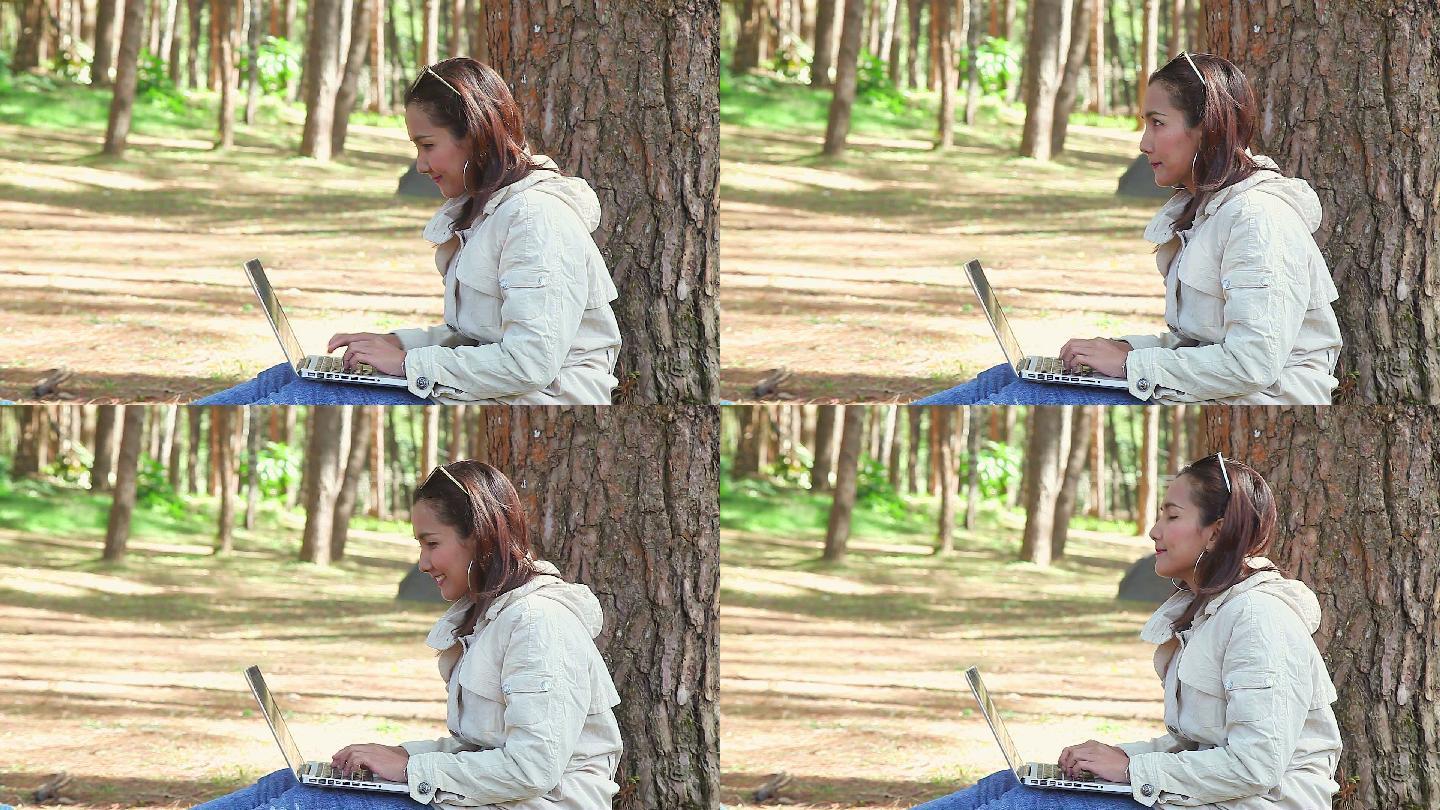 女人在树林里愉快地打字聊天